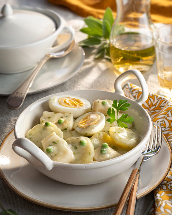 Plato con patatas, guisantes, merluza y huevo en salsa verde